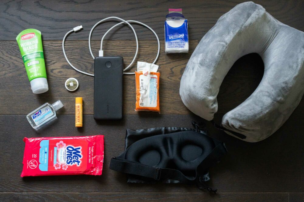 Long-flight essentials arranged in an open carry-on